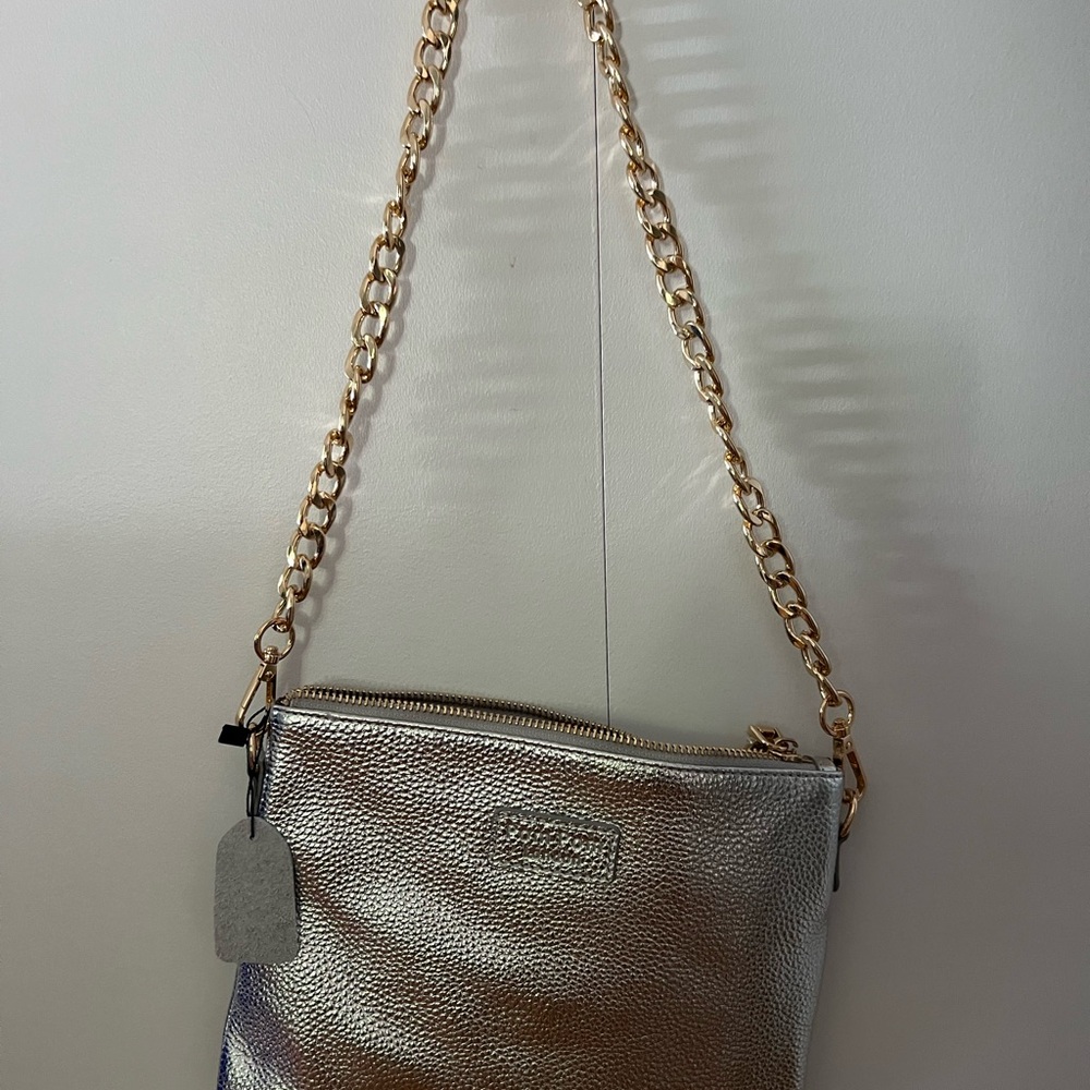 100% leather handbag with removable gold chain strap and clip on wristlet strap.